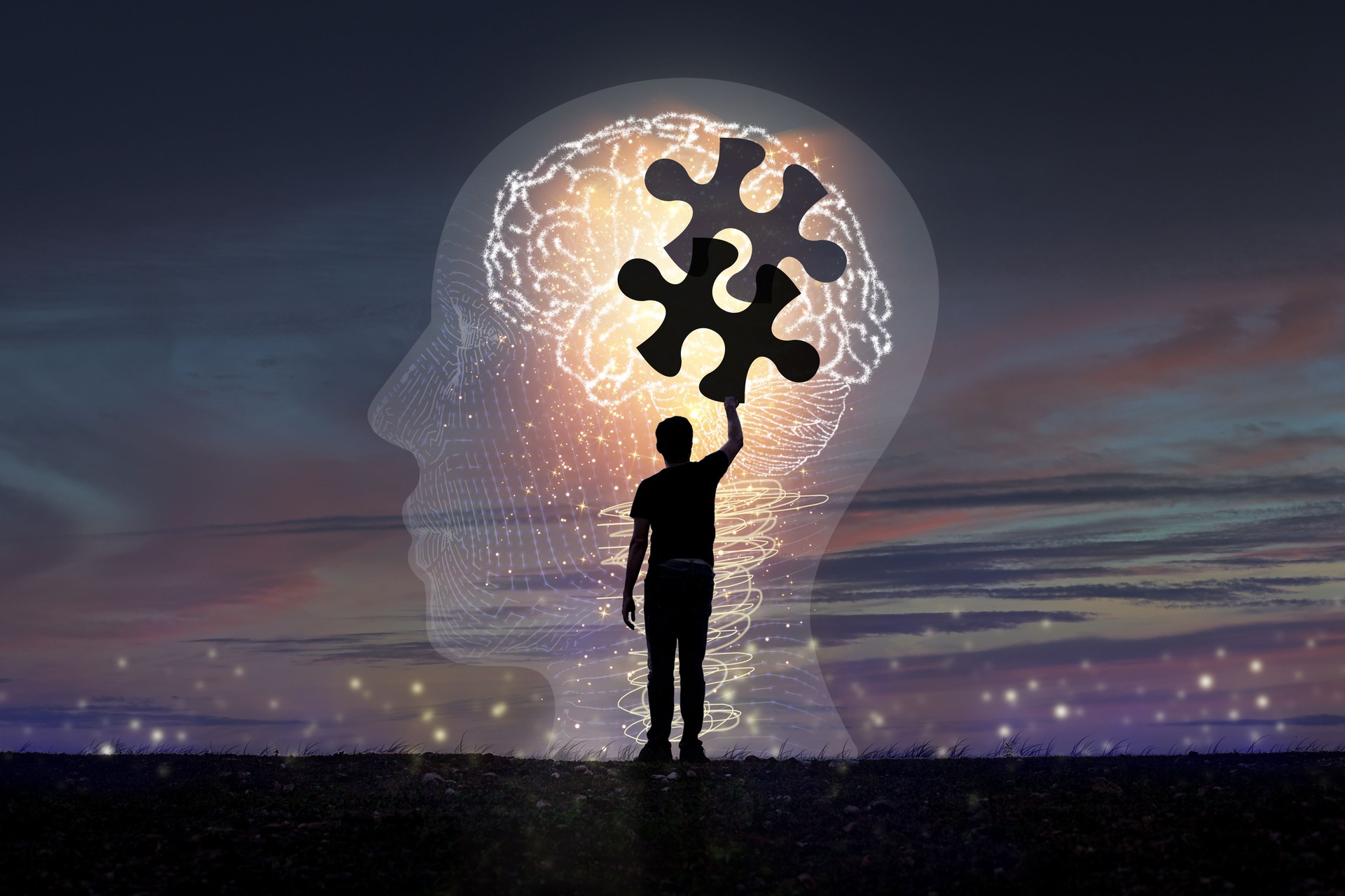 A young man's silhouette is piecing together a jigsaw puzzle. in brain icon concept creativity and innovation A young man's silhouette is piecing together a jigsaw puzzle. in brain icon concept creativity and innovation